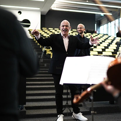 Homme chef d’orchestre brandissant la baguette et dirigeant un orchestre avec Guillaume Berney— Maestro for a Day